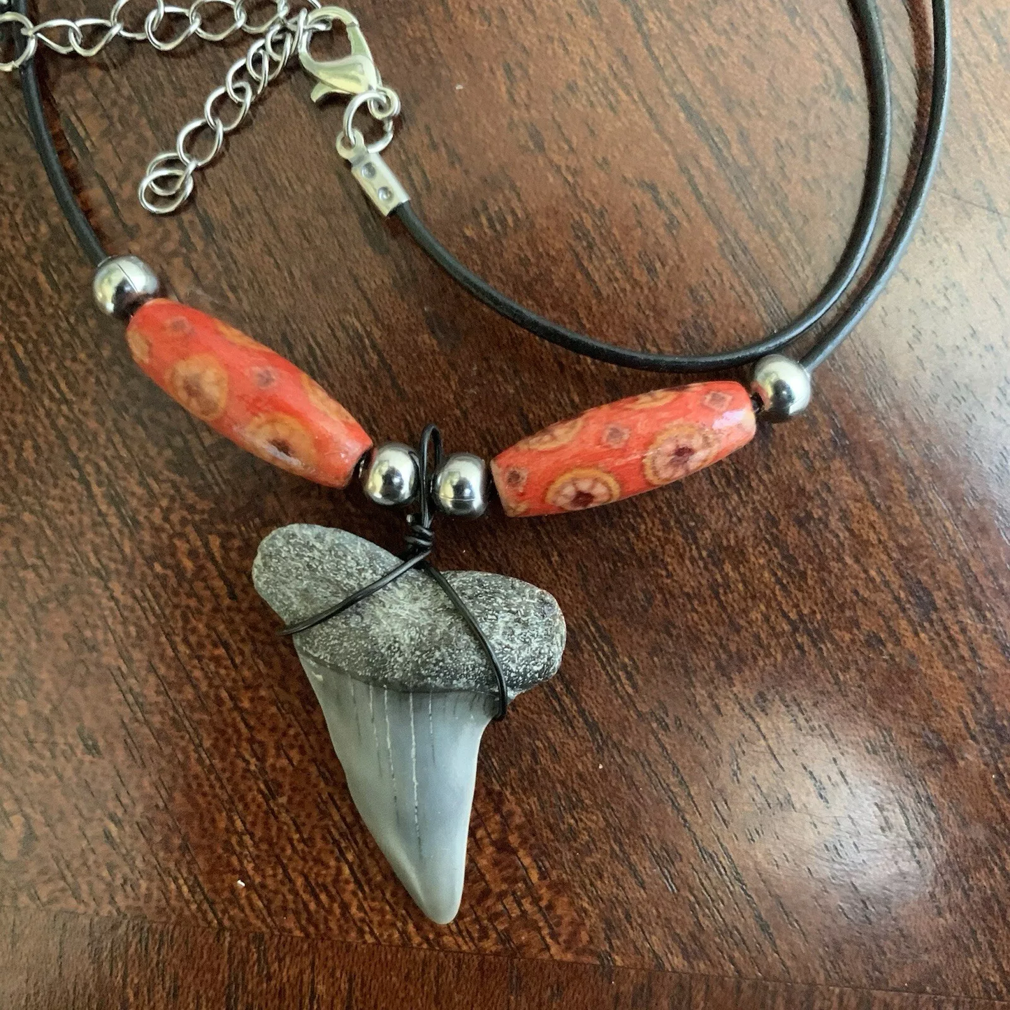 Real shark tooth necklace made from a fossil lesser white shark tooth pendant wrapped with black wire, hung on a black cotton cord with colorful beads