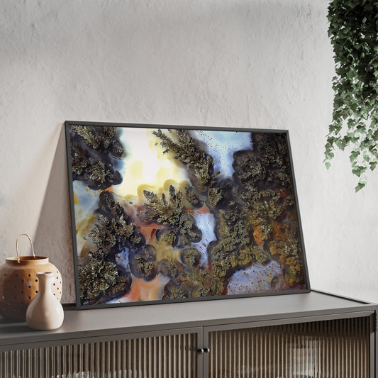 Wall art print capturing a captivating close-up photograph of a black plume agate with its  green white and yellow color. The picture is in a black frame and is leaning against the wall, on a low height cabinet, in the living room.