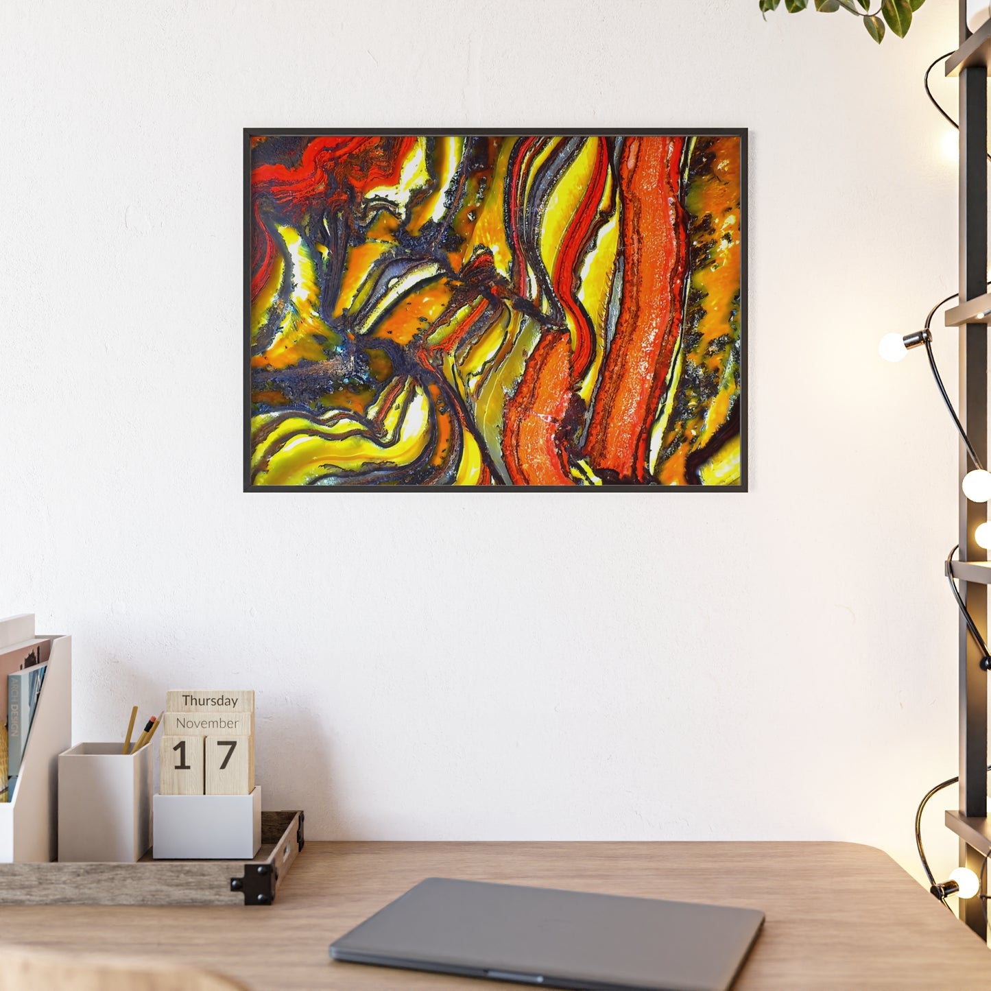Rock art wall print featuring some faulted and folded tiger iron with its vibrant red, yellow and black colors.  The picture is in a black frame hanging above a desk in the bedroom of a home.