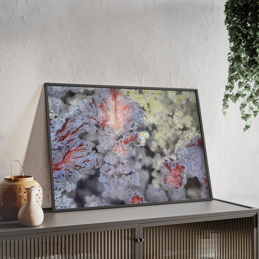 Wall art print capturing a captivating close-up photograph of a scenic moss agate with its bblue, red and yellow color. The picture is in a black frame and is leaning against the wall, on a low height cabinet, in the living room.