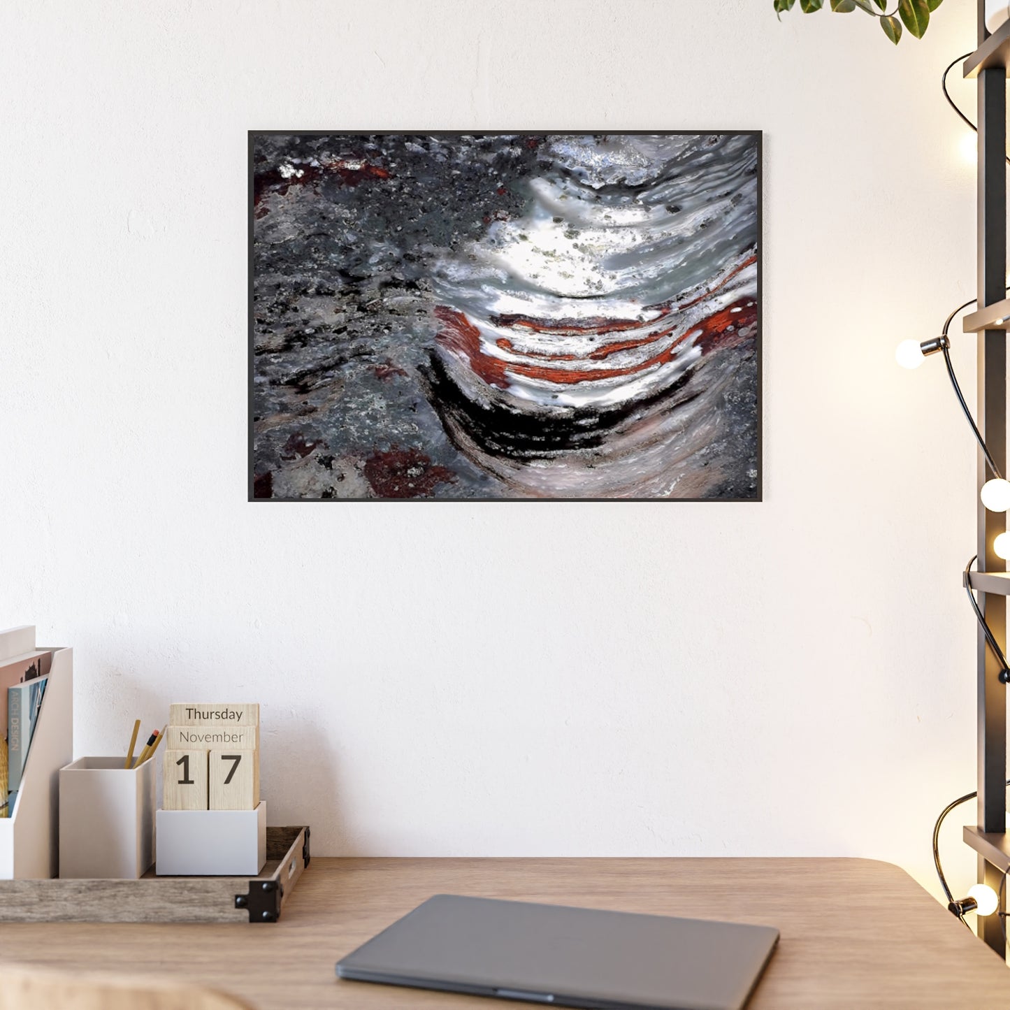 Rock art wall print featuring the stromatolite Collenia undosa with its vibrant grayred and white  colors.  The picture is in a black frame hanging above a desk in the bedroom of a home.