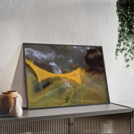 Wall art print capturing a captivating close-up photograph of a timor agate with its yellow, white and brown colors. The picture is in a black frame and is leaning against the wall, on a low height cabinet, in the living room.